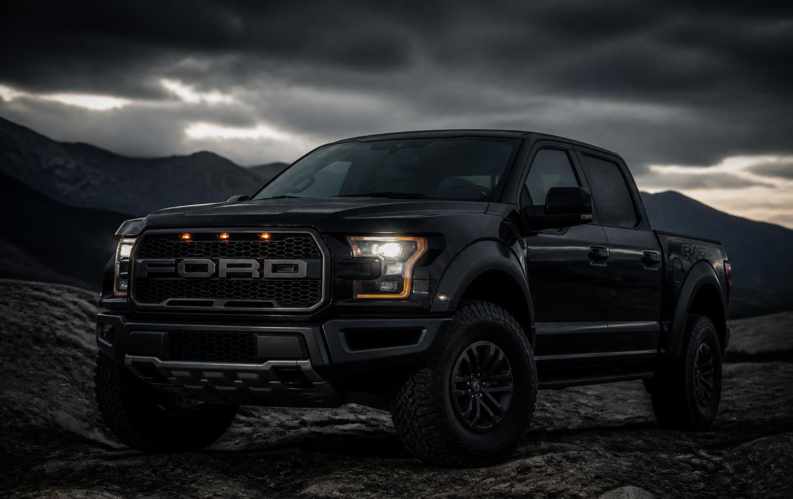 Black Ford F-150 Raptor pickup on rocky terrain